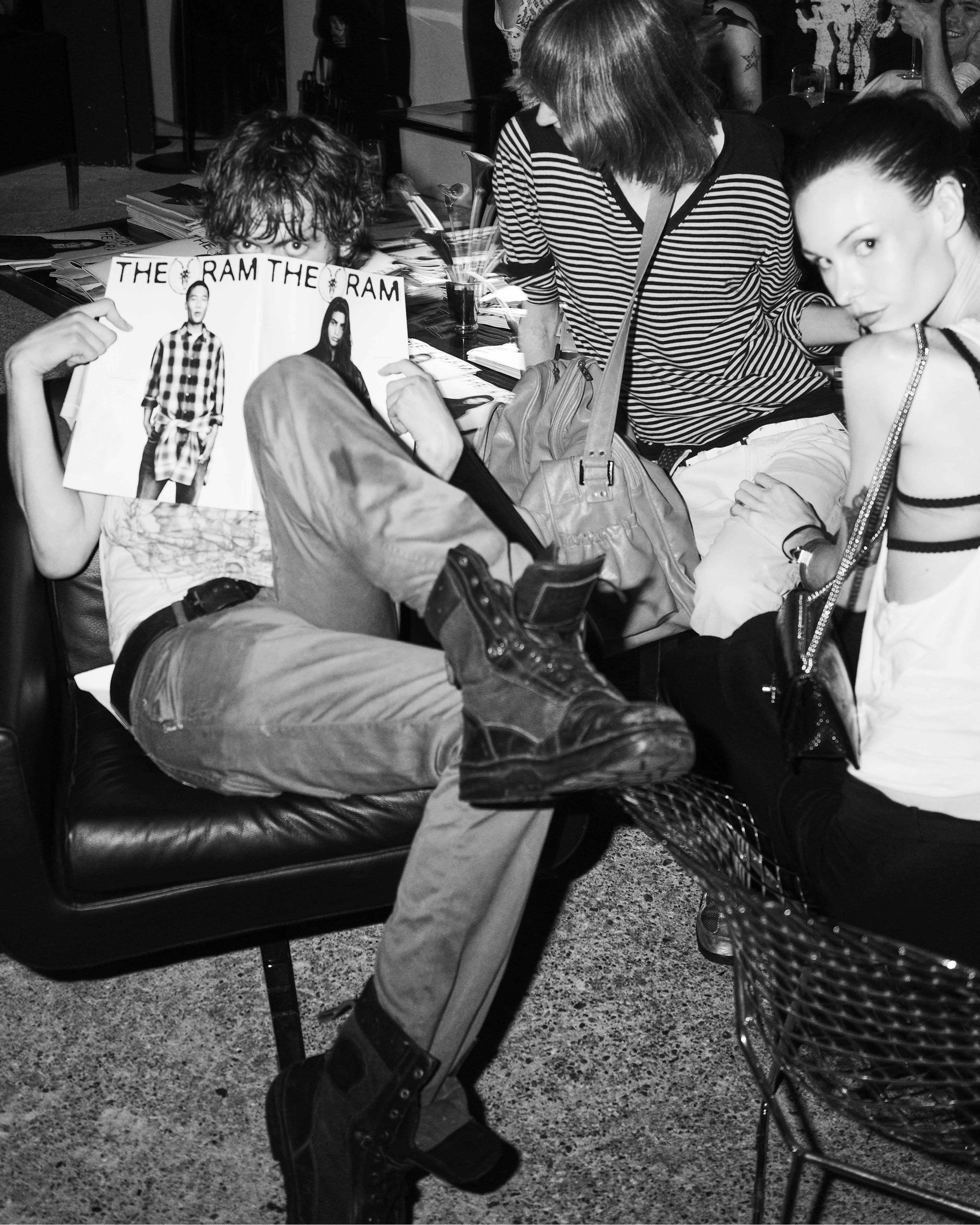 Black-and-white photo of guests relaxing on a sofa at the AllSaints Autumn Winter 26 Launch Party.