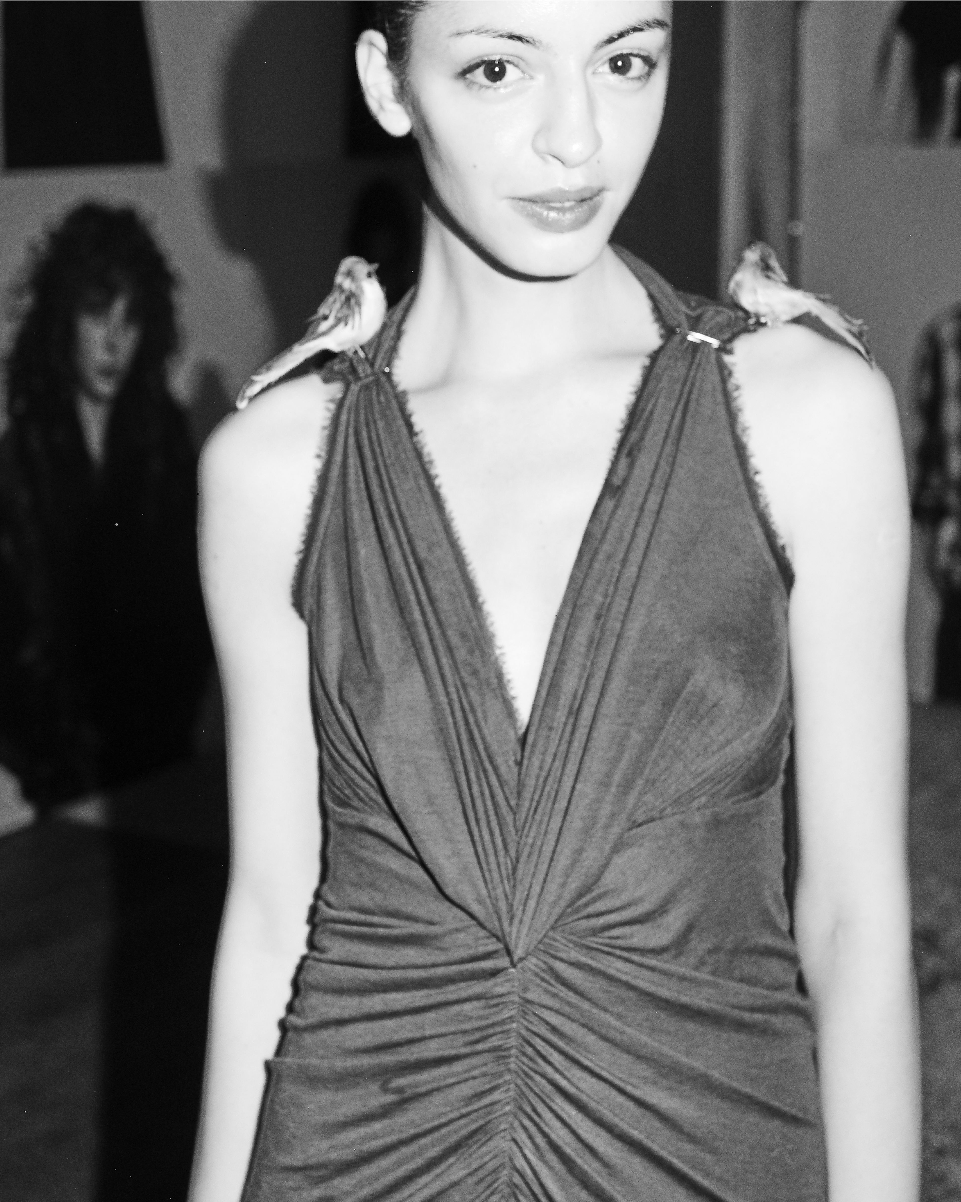 Black-and-white portrait of a guest wearing a draped sleeveless dress at the AllSaints Autumn Winter 26 Launch Party.