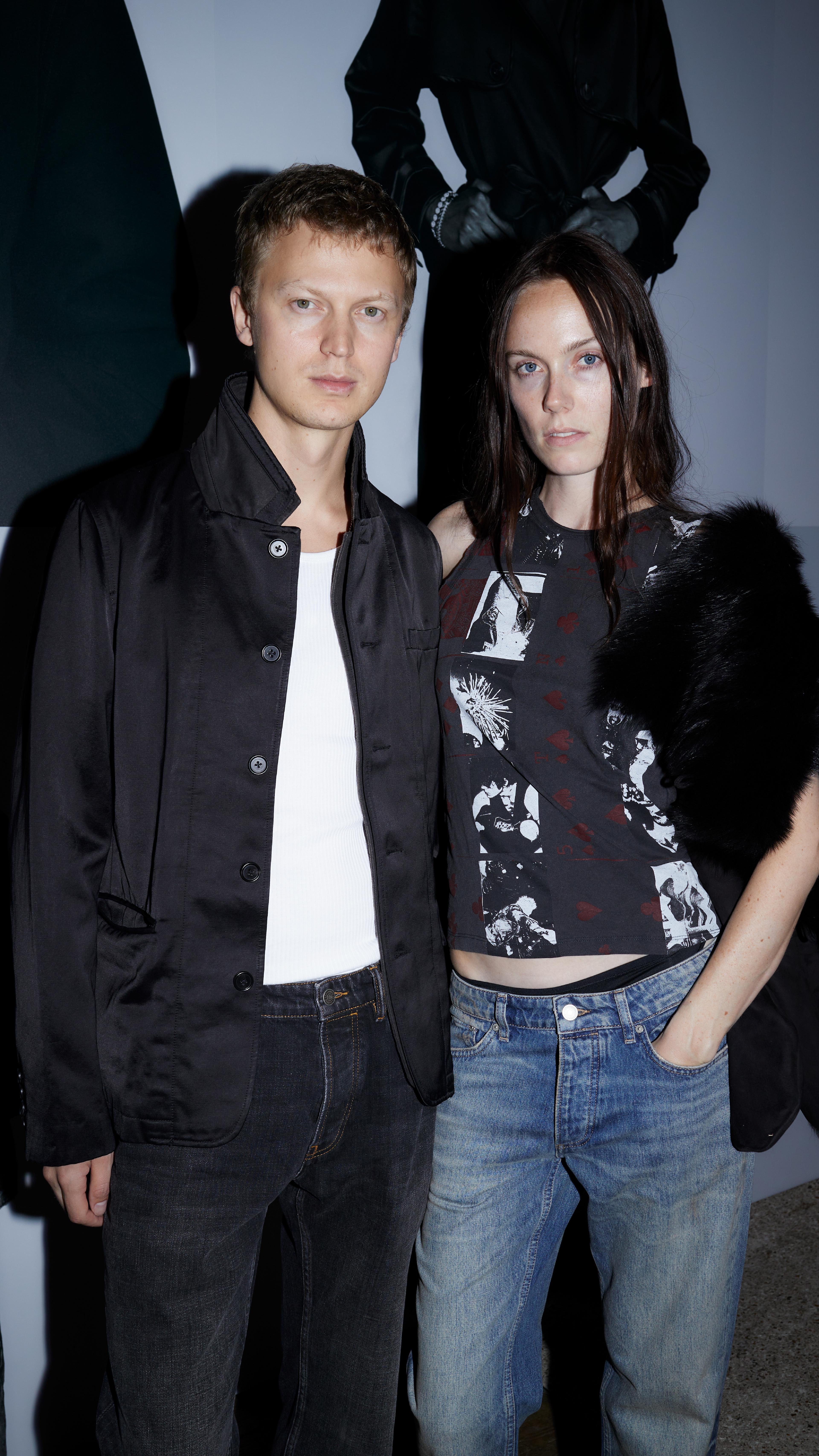 Two guests posing together in dark jackets and denim at the AllSaints Autumn Winter 26 Launch Party.